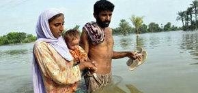 Una familia pakistaní  cruza una zona inundada