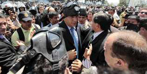 El presidente ecuatoriano, Rafael Correa (c), es protegido del gas lacrimógeno este, jueves 30 de septiembre 