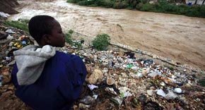 Un niño haitiano observa el caudal de un río incrementado por el huracán Tomas, en un sector de Puerto Príncipe, Haití 
