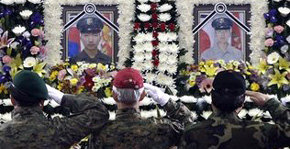 Veteranos de la infantería de Marina saludan los retratos de los dos infantes de Marina surcoreanos muertos 