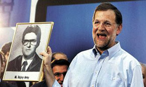 Mariano Rajoy muestra el retrato de su orla, recibida de manos de un militante en Sevilla

