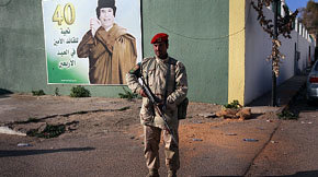 Un soldado libio leal a Gadaffi frente a un cartel con la imagen del líder