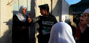 Una policía palestina indica el camino a una mujer palestina 
