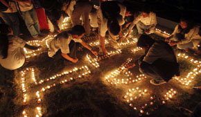 Un grupo de ciudadanos nepalíes enciende velas en la víspera del día mundial de la tuberculosis 