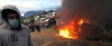 Quema de un vehículo antidisturbios durante los enfrentamientos de este jueves entre manifestantes y Carabineros en Puerto Aysén, en la Patagonia chilena 