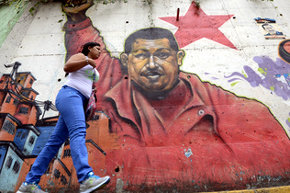 Una mujer pasa frente a un mural de Chávez en Caracas