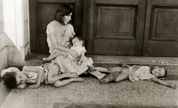 Foto de una madre sin hogar con sus tres hijos 
