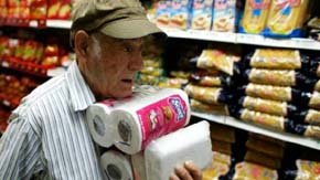 Un venezolano hace acopio de comida y papel higiénico en un supermercado en Caracas