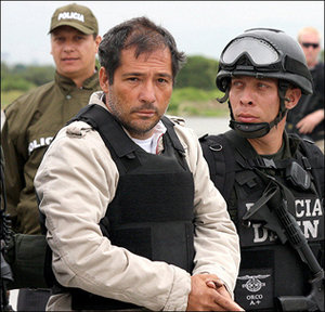 Miguel Angel Mejia Munera, alias 'El Mellizo'', escoltado por efectivos de la Policía colombiana a su llegada a la base antinarcóticos de esa institución 