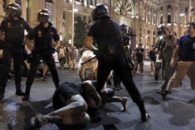 Un manifestante se agarra a la pierna de un antidisturbios durante las cargas en Cibeles. JAIRO VARGAS 
