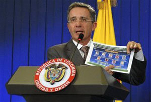 Alvaro Uribe muestra un aviso de la policía que ofrece recompensas de hasta dos millones de dólares. 