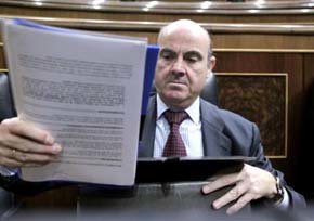 El ministro de Economía, Luis de Guindos, se dispone a guardar unos papeles en su cartera. 