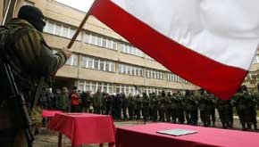 Un hombre armado, supuestamente un soldado ruso, ondea una bandera de Rusia en Simferópol, capital de Crimea (Reuters).