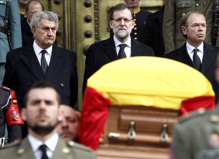 El presidente del Gobierno, Mariano Rajoy (c), los presidentes del Congreso, Jesús Posada (i), y del Senado, Pío García Escudero (d), observan el féretro de Adolfo Suárez, portado por un piquete de honor, que ha abandonado el Congreso de los Diputados por la escalinata de la Puerta de los Leones, donde se han colocado las numerosas autoridades presentes en este acto y la familia del expresidente, y en presencia de compañías de los tres ejércitos y de la Guardia Civil. EFE