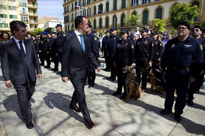 El secretario de Estado de Seguridad, Francisco Martínez (c) y el director general de la Policía, Ignacio Cosidó (i) hoy en Málaga, pasa revista momentos antes del acto de imposición a María Santísima del Amor de la Cofradía de Nuestro Padre Jesús El Rico de la Medalla de Oro al Mérito Policial, máxima distinción de la Policía. EFE