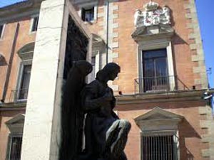 Godofredo Chicharro coloca una corona de laurel en el Monumento de la calle Mayor de Madrid frente a Casa Ciriaco