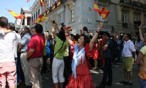 Una ciudadana celebra vestida de sevillana la proclamación de Felipe VI. Foto: Luis Marchal