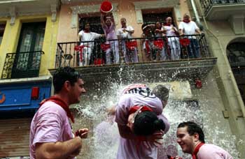 Vecinos echan agua a los viandantes en San Fermín. (Reuters)