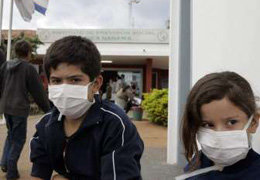 Dos niños con mascarillas esperan ser atendidos en un centro de salud de la capital