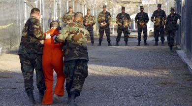 Policía militar de EEUU traslada a un detenido en Camp X-Ray, en la base de Guantánamo, en una imagen de 2002 (Reuters).