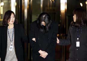 Cho Hyun-ah custodiada por dos agentes tras su detención en Seúl. REUTERS 