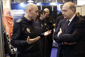 El ministro del Interior, Jorge Fernández Díaz,d., conversa con un policía ,durante la inauguración del V Salón Internacional de Tecnologías de Seguridad Nacional HOMSEC, hoy en el recinto ferial de IFEMA. EFE