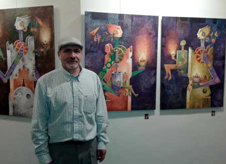 Orlanddo Arias frente a algunos de sus cuadros