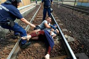 Una pareja de refugiados con un bebé trata de zafarse de la policía en la estación de tren de Bicske 