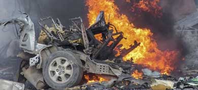 Un coche arde tras la explosión de un coche bomba frente el hotel Sahafi de Mogadiscio, Somalia 