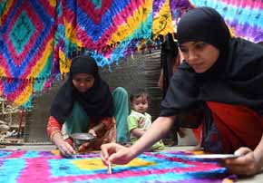 Trabajadoras paquistaníes confeccionan alfombras en su casa de Karachi