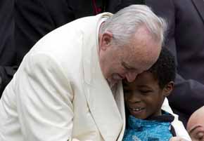 Francisco junto a un niño luego de una audiencia papal en la plaza San Pedro