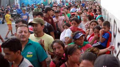 Un grupo de ciudadanos ecuatorianos hace cola en espera de recibir las ayudas