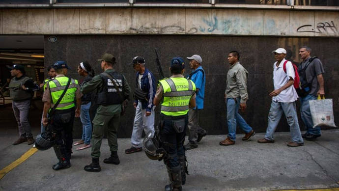 Un grupo de personas hace fila en las inmediaciones del Banco Central de Venezuela en Caracas