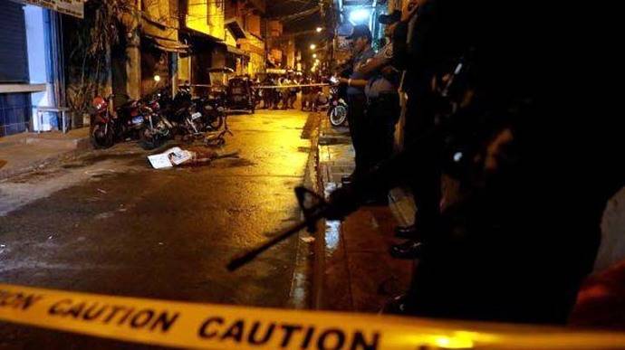 Policías rodean el cuerpo de una persona muerta durante un operativo antidrogas en el Metro de Manila 