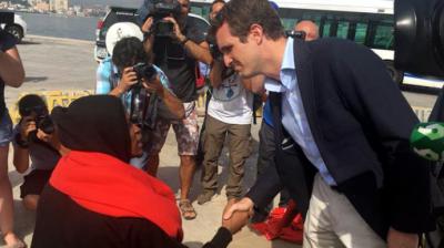 El presidente del PP, Pablo Casado, saluda a un joven inmigrante en el puerto de Algeciras. JOSÉ CARLOS VILLANUEVA