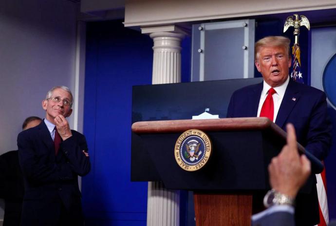 La imagen del doctor Fauci llevándose la mano a la cara en plena conferencia de prensa mientras Trump hablaba sobre una supuesta conspiración contra él 