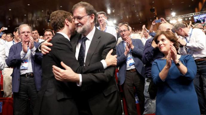 Pablo Casado y Mariano Rajoy se abrazan tras la victoria del primero en las primarias del PP.