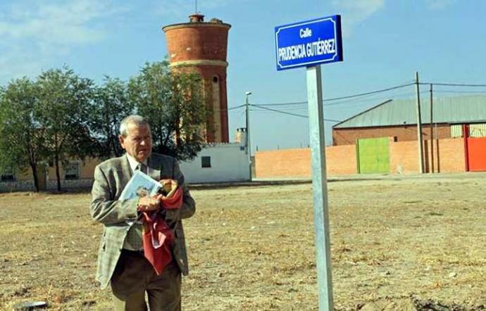 José Antonio Sierra Lumbreras junto al indicador del nombre de la calle Prudencia Gutiérrez en Crespos, Ávila, que promovió en reconocimiento al altruismo de esta vecina del municipio