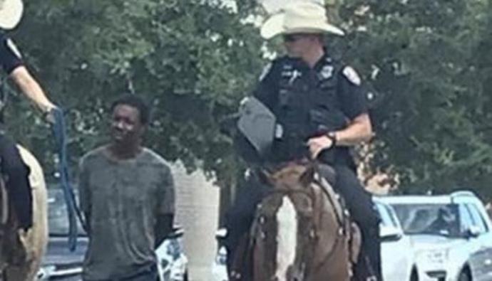Policías atan con soga a un preso esposado y lo llevan por las calles de Texas