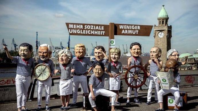 Activistas de Oxfam posan en Hamburgo, Alemania, disfrazados como algunos de los líderes que participarán en la cumbre del G20