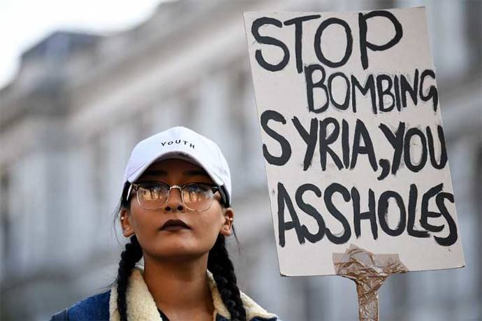 Una manifestante protesta contra la decisión de Donald Trump de bombardear una base aérea en Siria el viernes en la madrugada.