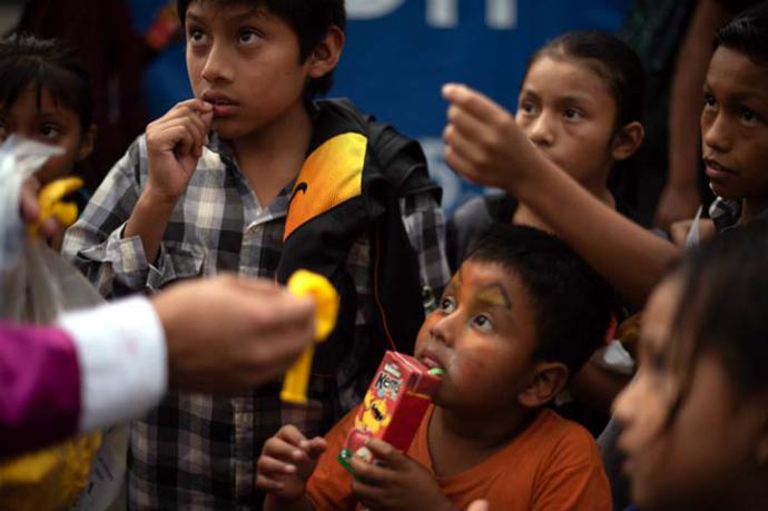 Varios niños esperan a que les entreguen globos durante el entierro de una de las víctimas que ha dejado la erupción del Volcán de Fuego 