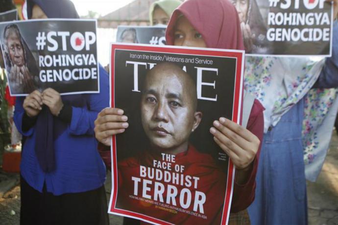 Varios manifestantes sostienen pancartas a con la imagen del monje budista Wirathu 