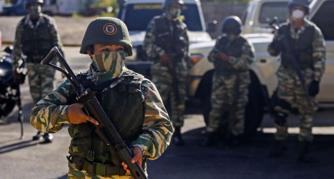 Los militares de la Guardia Nacional Bolivariana vigilan una autopista a la entrada de Caracas