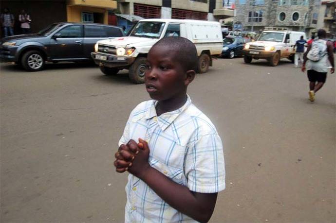 Un niño reza por las víctimas en una calle de Freetown