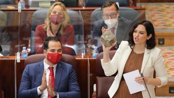 La presidenta de la Comunidad de Madrid, Isabel Díaz Ayuso, con un adoquin en la Asamblea de Madrid. 