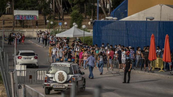 Decenas de personas esperan su turno en la entrada de la comisaría de extranjería de Aluche. Olmo Calvo