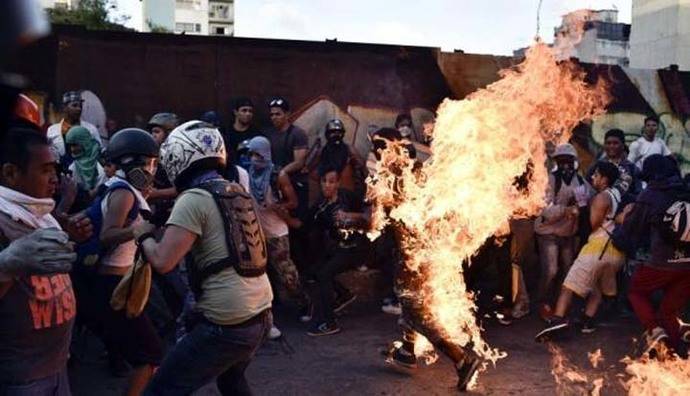 Un hombre corre envuelto en llamas luego de ser golpeado por manifestantes de la oposición de Venezuela en Caracas. 