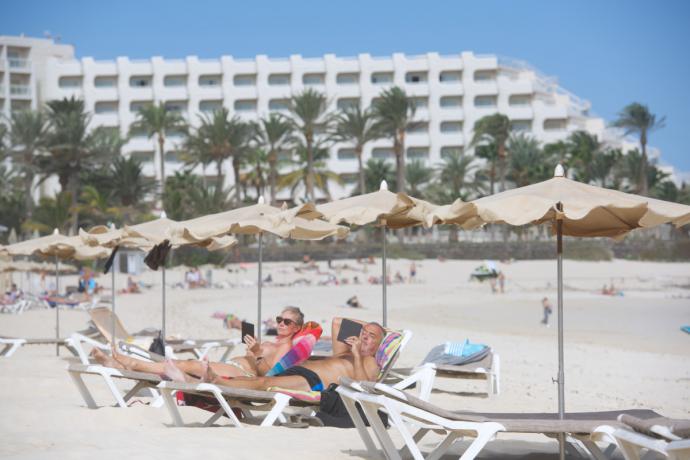 Varios turistas disfrutan del sol y de las buenas temperaturas en las grandes playas del municipio de Corralejo. Foto: EFE.