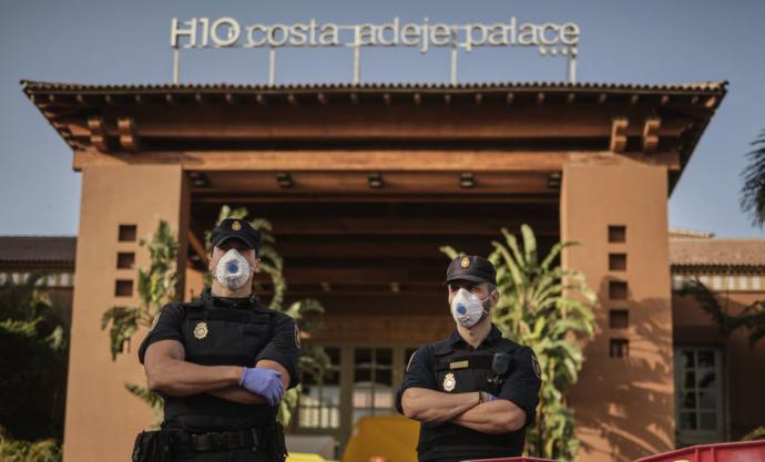 Policías con máscaras protectoras montan guardia frente al hotel H10 Costa Adeje Palace, en la isla canaria de Tenerife, España, que está en cuarentena por coronavirus